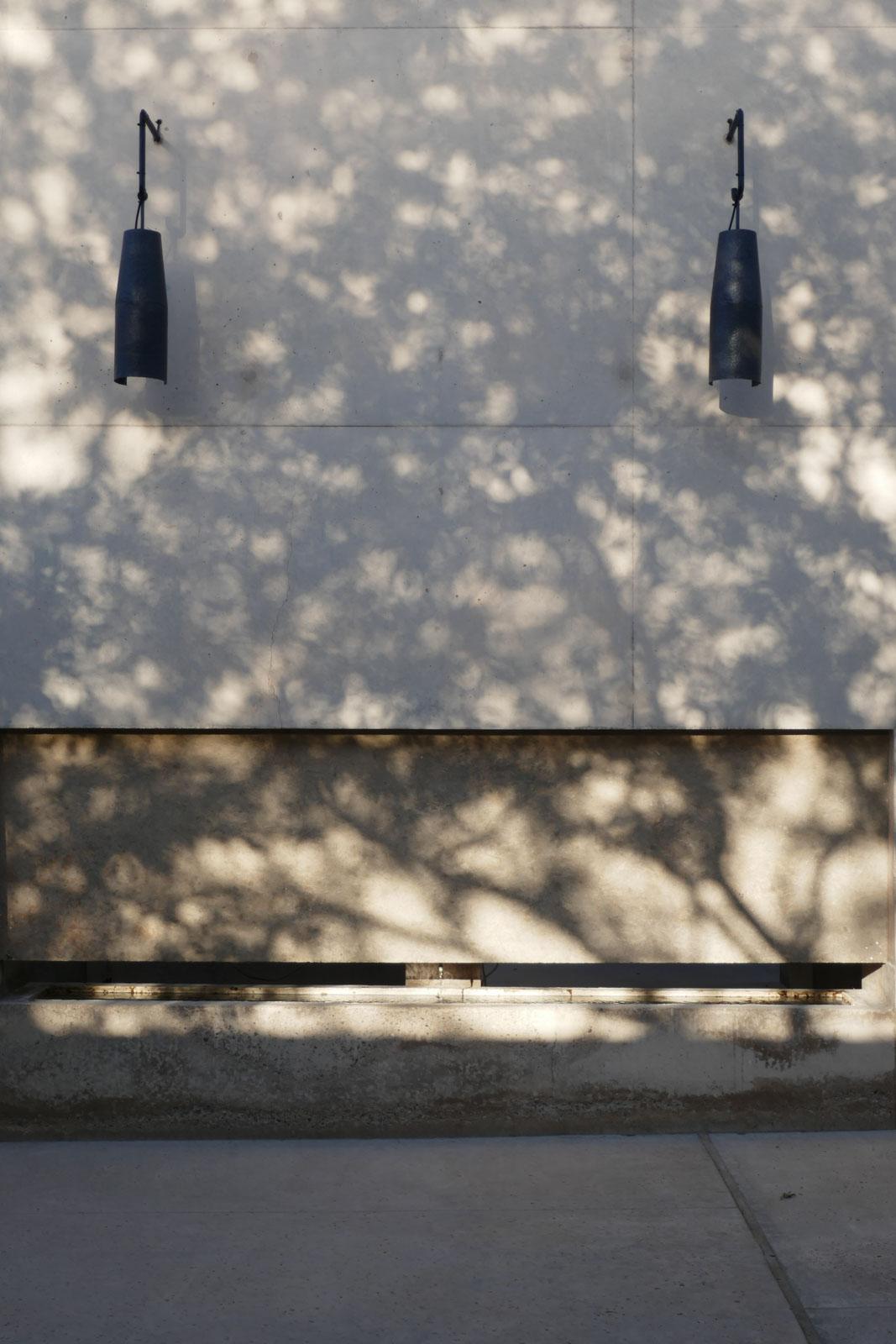 Chaque chambre est protégée par un paravent de bois et de béton, où coule une fontaine